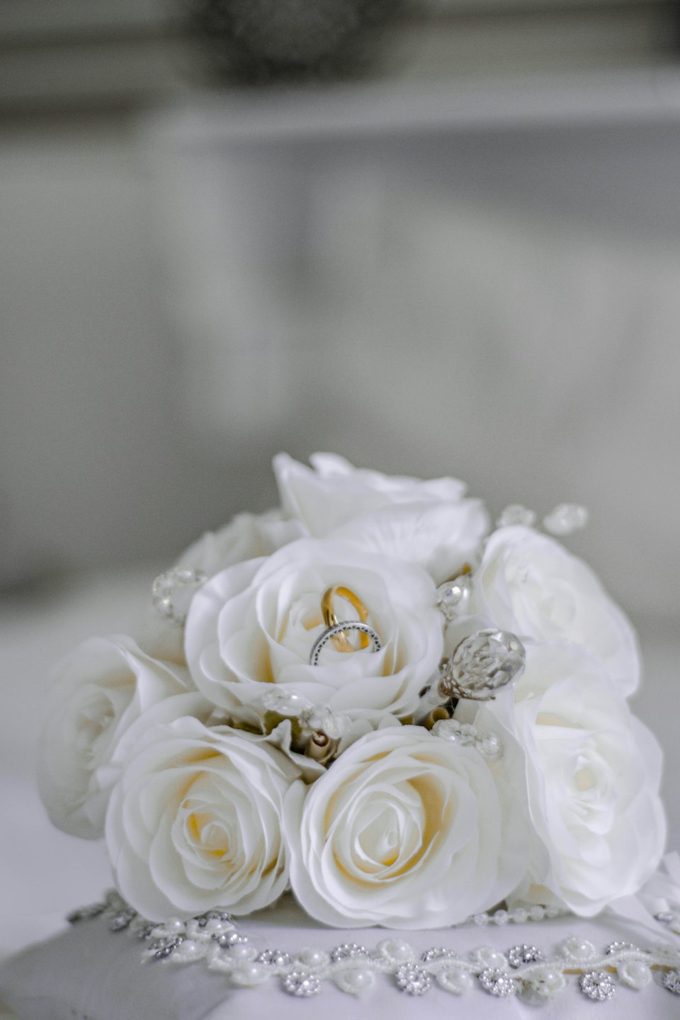 Gold and silver rings rest on a white rose.